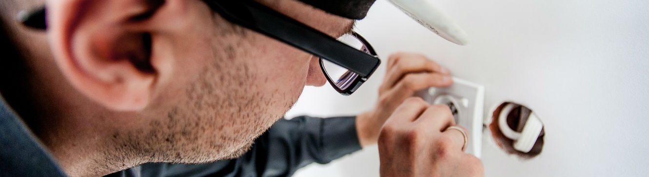 Un électricien du bâtiment installe une prise